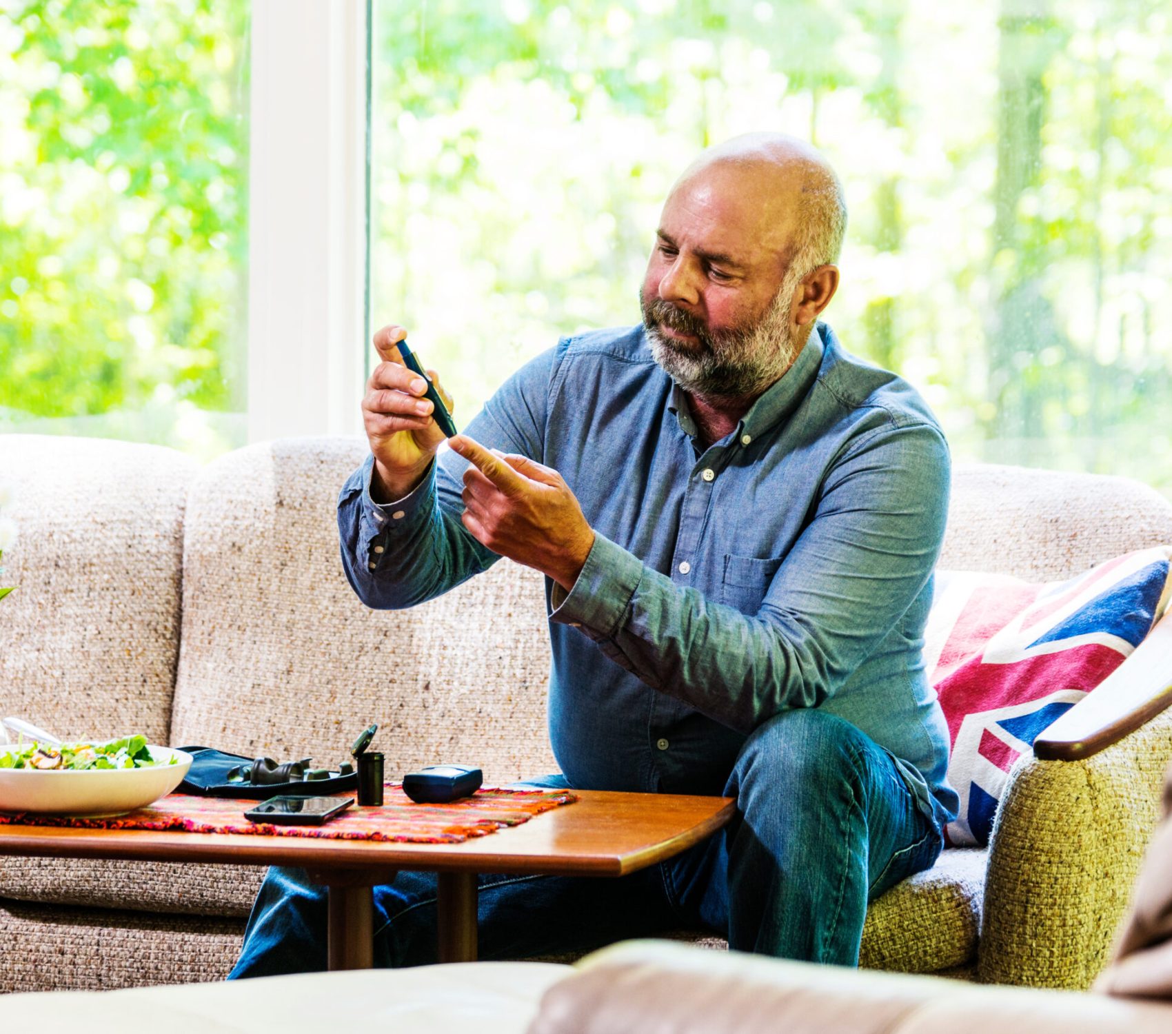 Mature, diabetic, ethnic man in his 50's checking his blood sugar